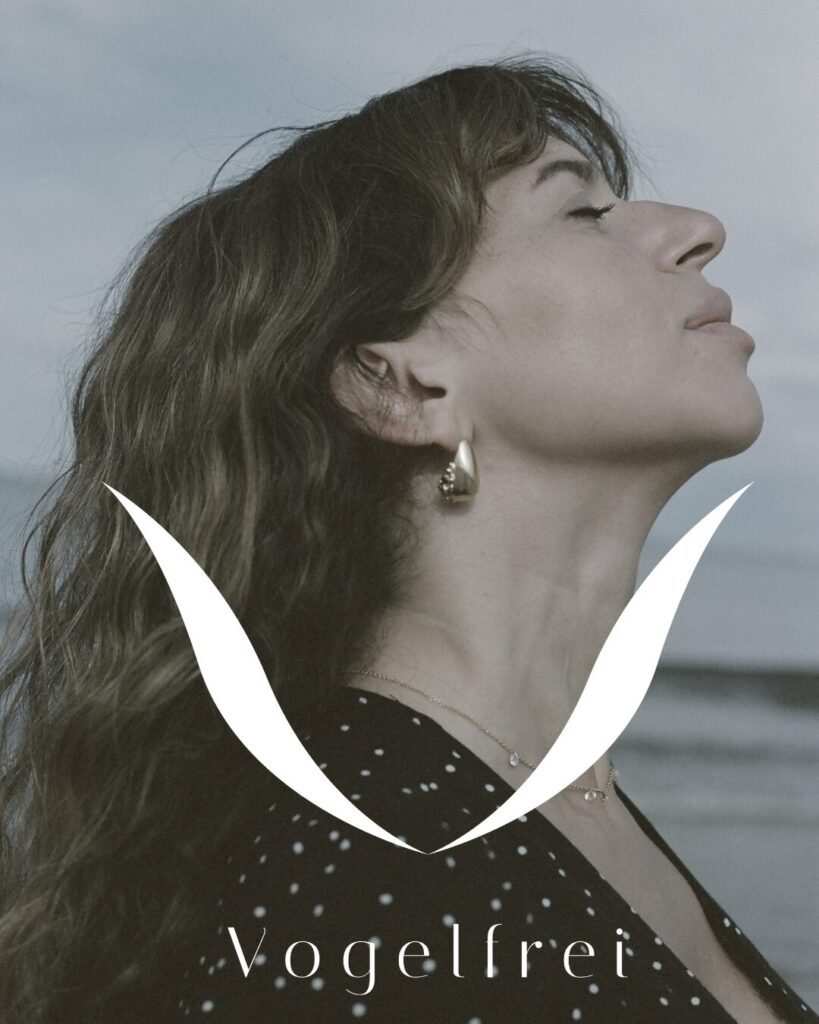 logo jeweler vogelfrei with woman in the background and sea